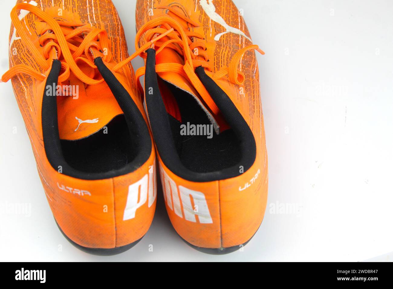 Dublino, Irlanda - 13 febbraio 2024: Una foto di scarpe da calcio arancioni PUMA Kids ultra 4,1 su una superficie bianca. Foto Stock
