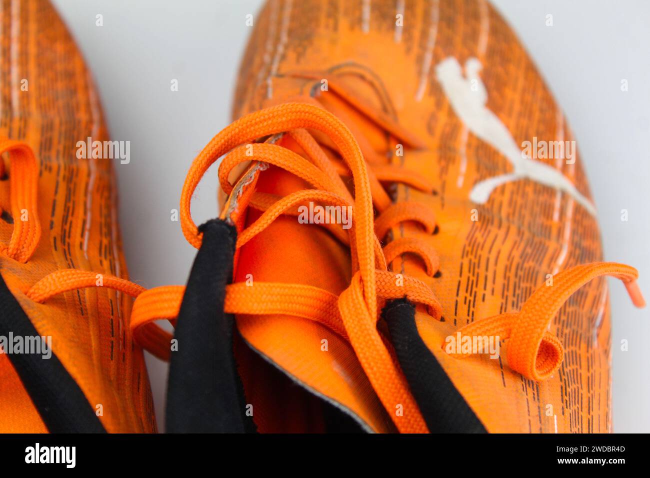 Dublino, Irlanda - 13 febbraio 2024: Una foto di scarpe da calcio arancioni PUMA Kids ultra 4,1 su una superficie bianca. Foto Stock