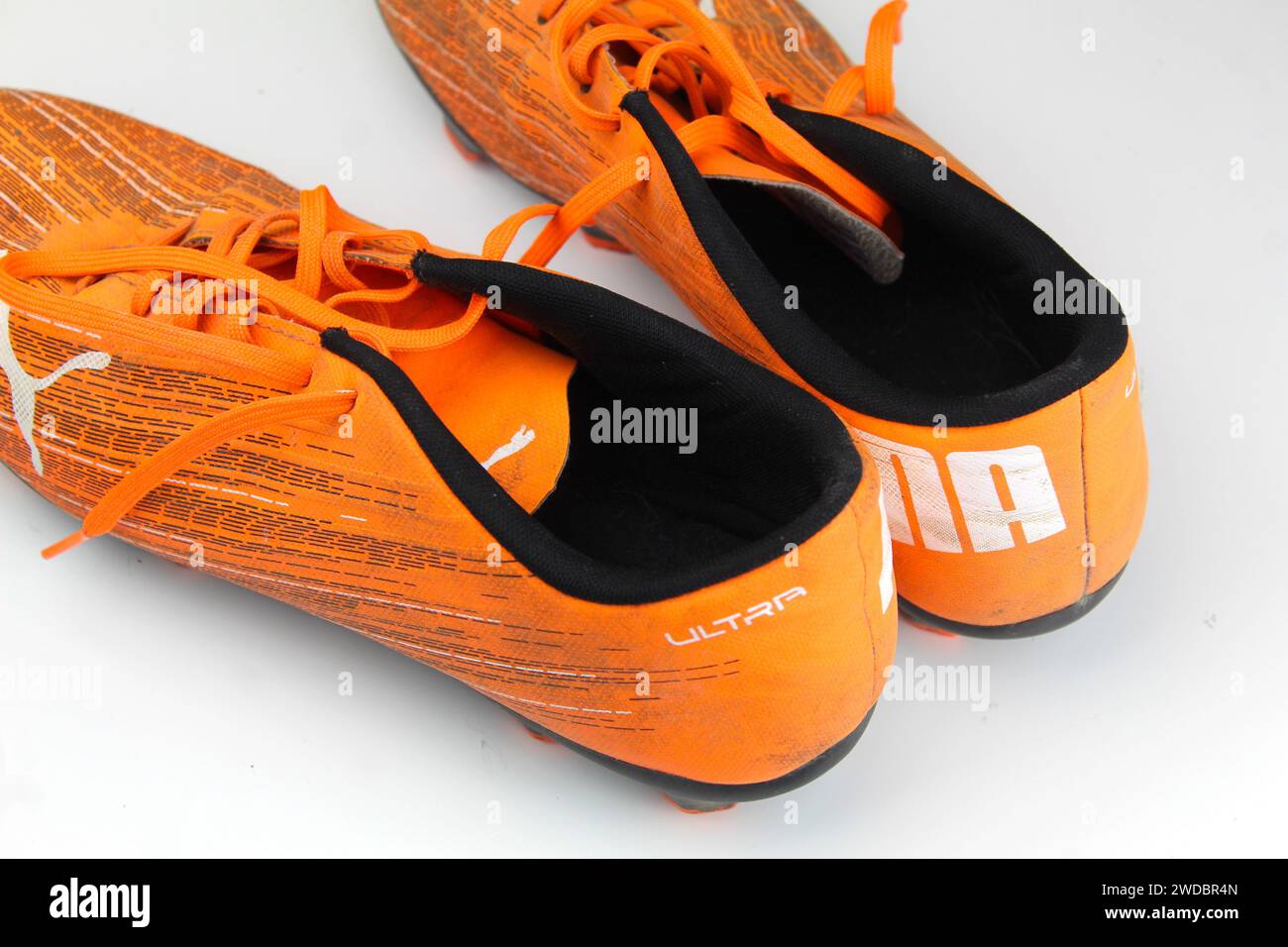 Dublino, Irlanda - 13 febbraio 2024: Una foto di scarpe da calcio arancioni PUMA Kids ultra 4,1 su una superficie bianca. Foto Stock