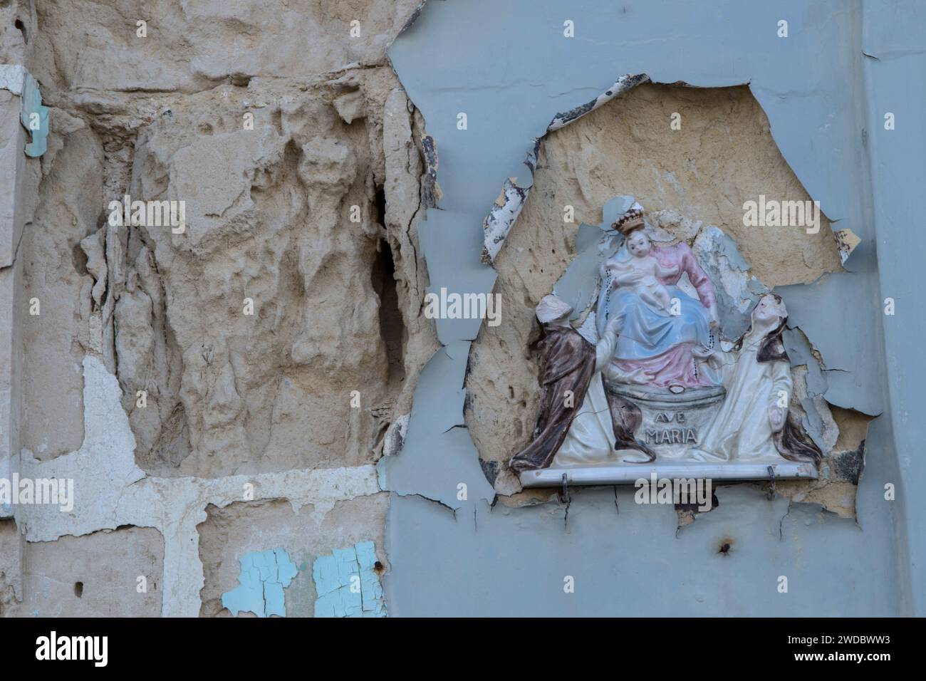 Arte cattolica un ikon di Cristo bambino in ceramica poco costoso e la Vergine Maria, una targa murale, rotta su un vecchio edificio abbandonato. Marsaxlokk, Malta, Isola di Malta, 2024, 2020s HOMER SYKES Foto Stock