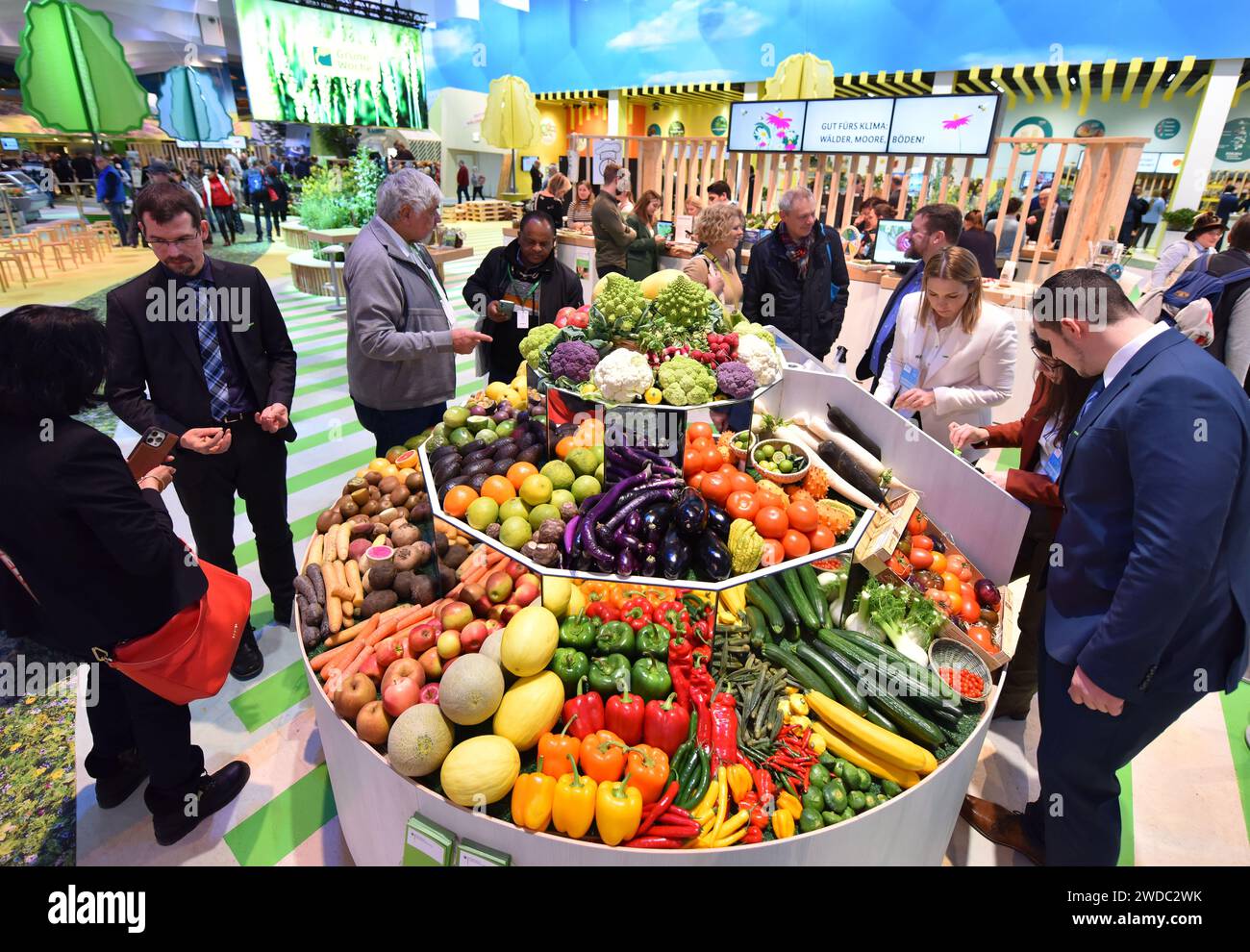 Berlino, Germania. 19 gennaio 2024. La gente visita uno stand di frutta e verdura durante la settimana verde internazionale a Berlino, in Germania, il 19 gennaio 2024. La settimana verde internazionale, una fiera leader nel settore dell'alimentazione, dell'agricoltura e dell'orticoltura, è stata aperta ai visitatori venerdì a Berlino e si svolgerà fino al 28 gennaio. Crediti: Ren Pengfei/Xinhua/Alamy Live News Foto Stock