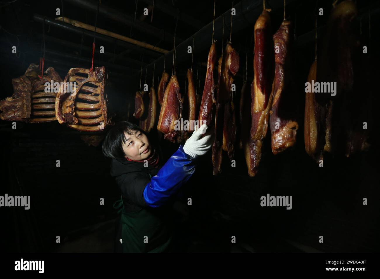 MEISHAN, CINA - 19 GENNAIO 2024 - la gente asciuga il proprio pollo stagionato all'aria nella comunità Luoping nella città di Meishan, provincia del Sichuan, Cina, 19 gennaio 202 Foto Stock