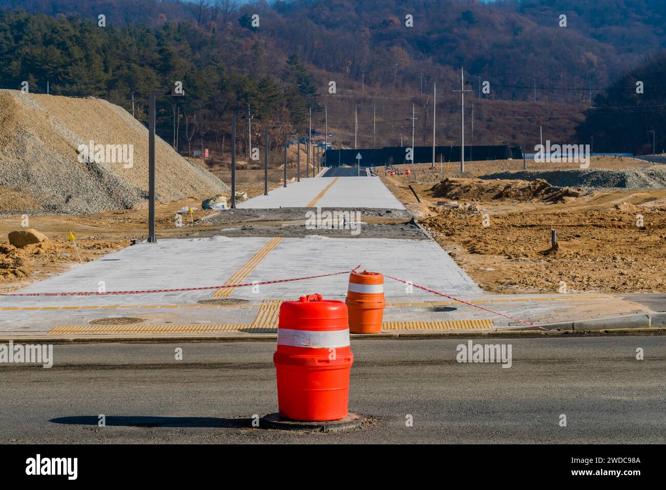 Barili che bloccano l'accesso alla nuova strada in cemento presso il cantiere, Corea del Sud, Corea del Sud Foto Stock