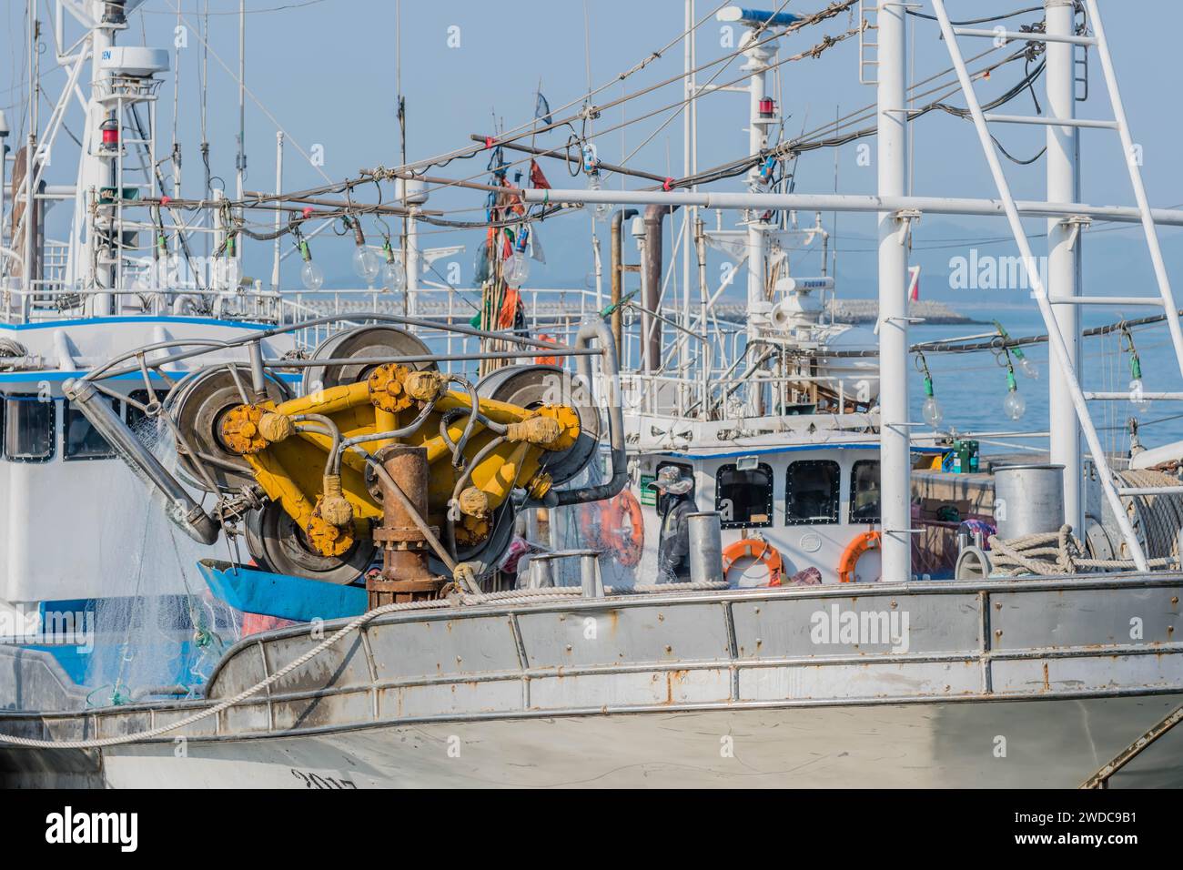 Verricello a tamburo utilizzato con reti da pesca sul ponte di pescherecci da traino ormeggiati al porto marittimo, Corea del Sud, Corea del Sud Foto Stock