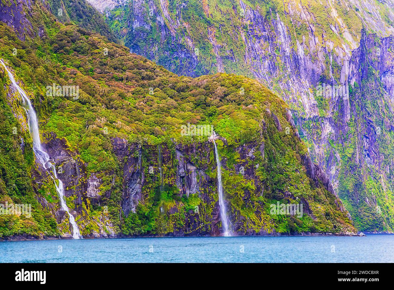 Ripide vette rocciose intorno al fiordo di Milford Sound sull'Isola del Sud della nuova Zelanda con le cascate di Stirling. Foto Stock