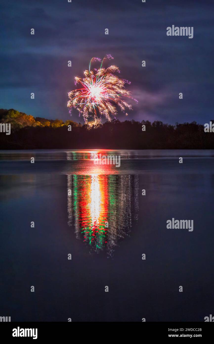 Fuochi d'artificio di notte di Capodanno sul lago Macquarie in Australia che si riflettono in acque ferme. Foto Stock