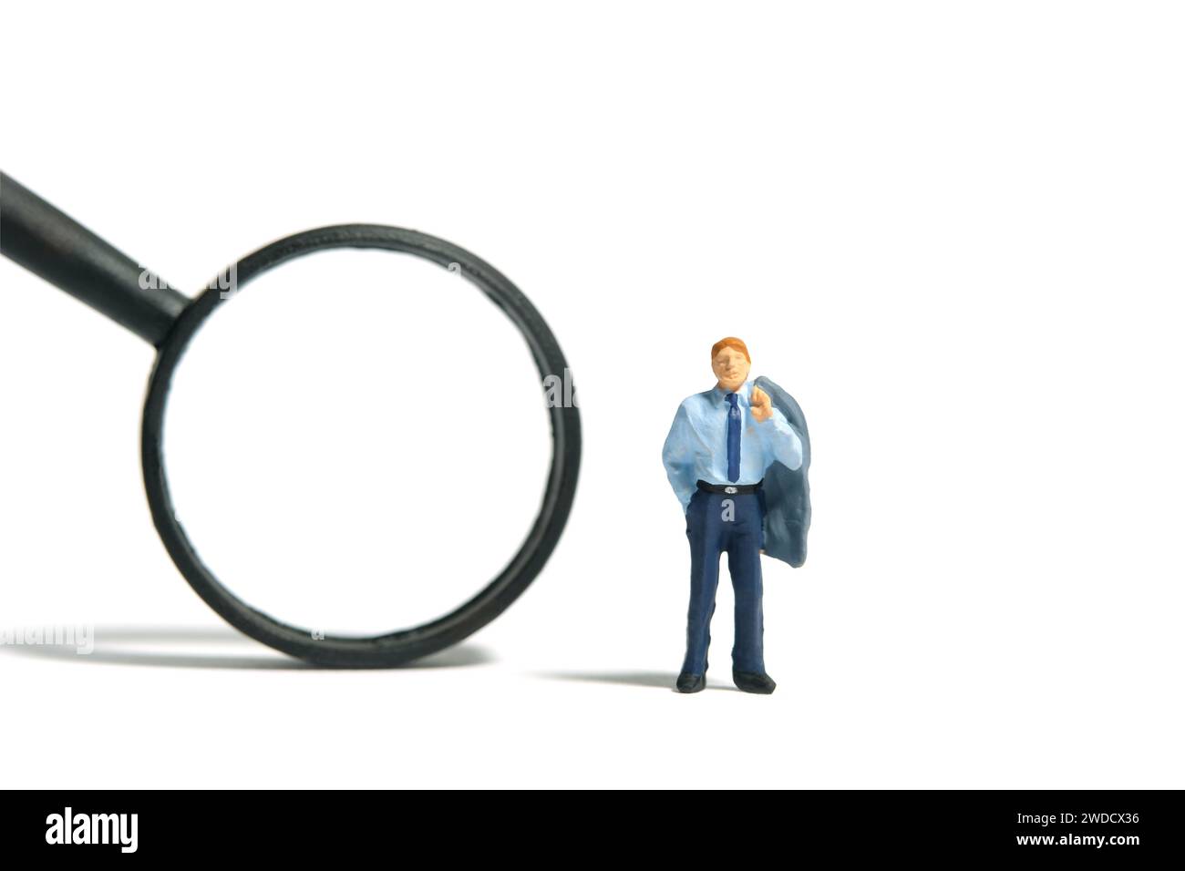 Fotografia di figure giocattolo in miniatura. Un uomo d'affari in piedi accanto alla lente d'ingrandimento nera. Isolato su sfondo bianco. Foto immagine Foto Stock