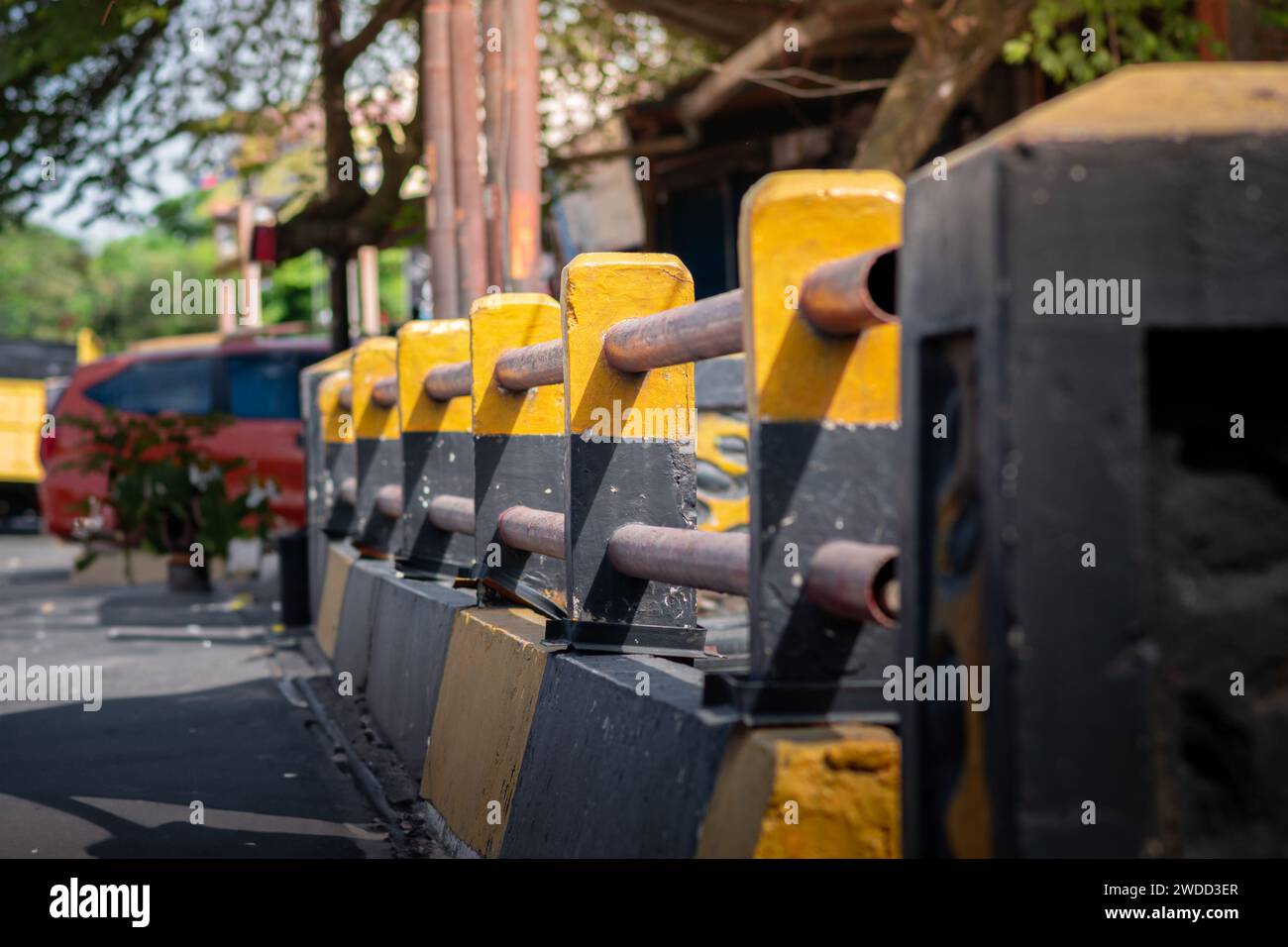 Strada gialla e nera e ringhiere sul marciapiede. Ripresa con messa a fuoco selettiva. Foto Stock