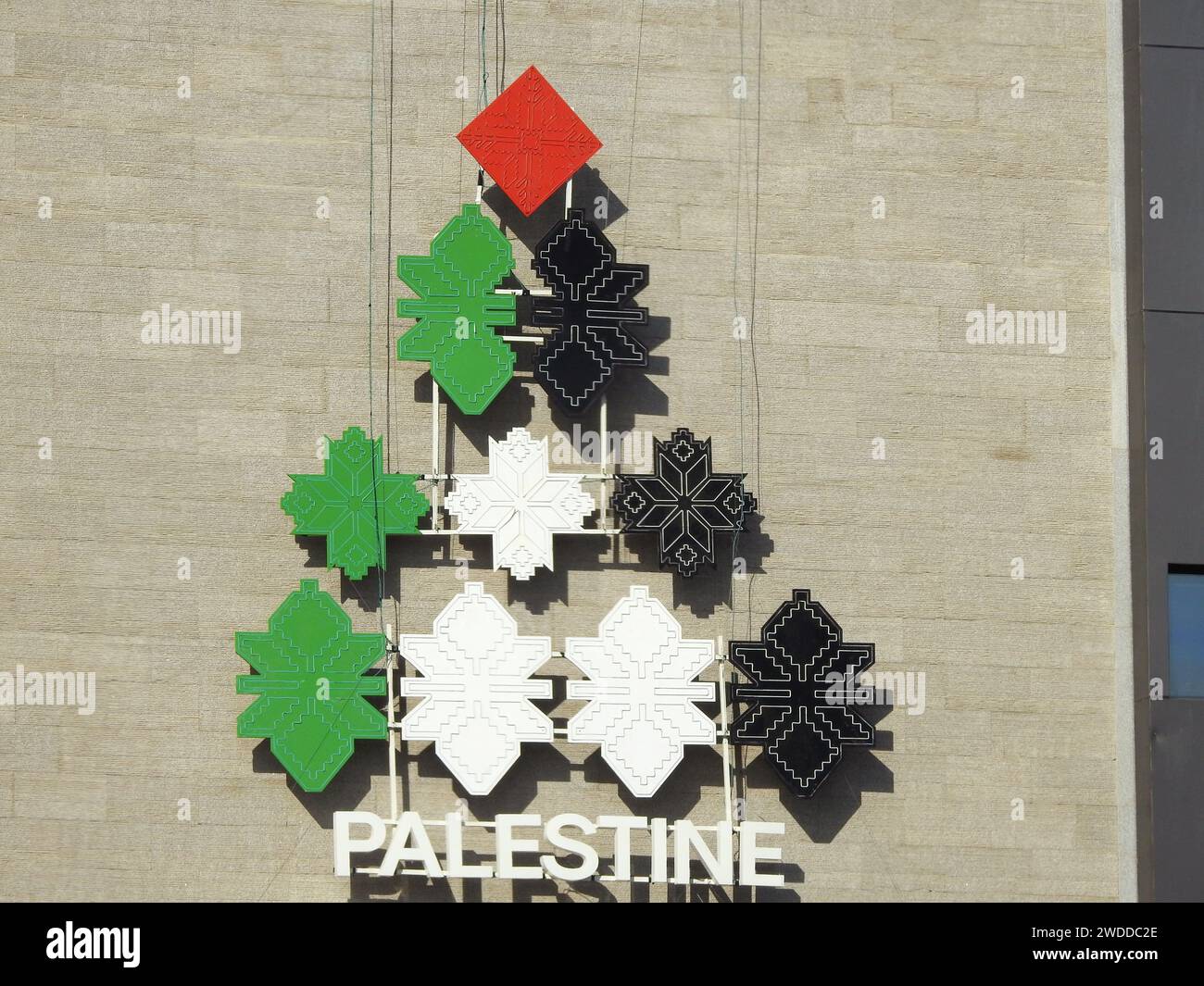 Una forma piramidale con i colori della bandiera palestinese, con la parola Palestina sotto di essa, un'icona su un edificio in Egitto per lo stato della Palestina Foto Stock