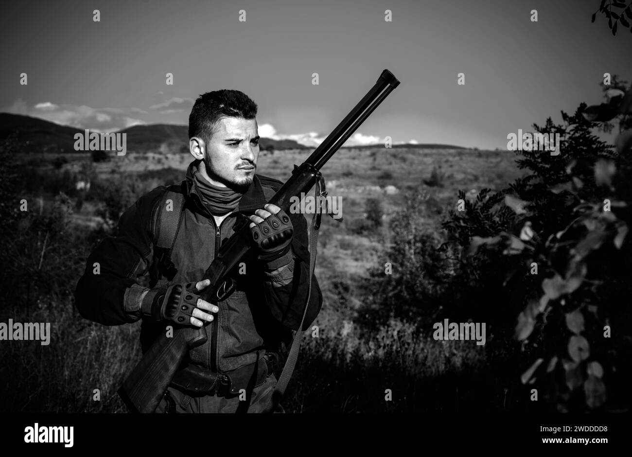 Hunter in movimento con fucile in cerca di preda. Cacciatore in abiti mimetizzazione pronti a caccia con fucile da caccia. Foto Stock