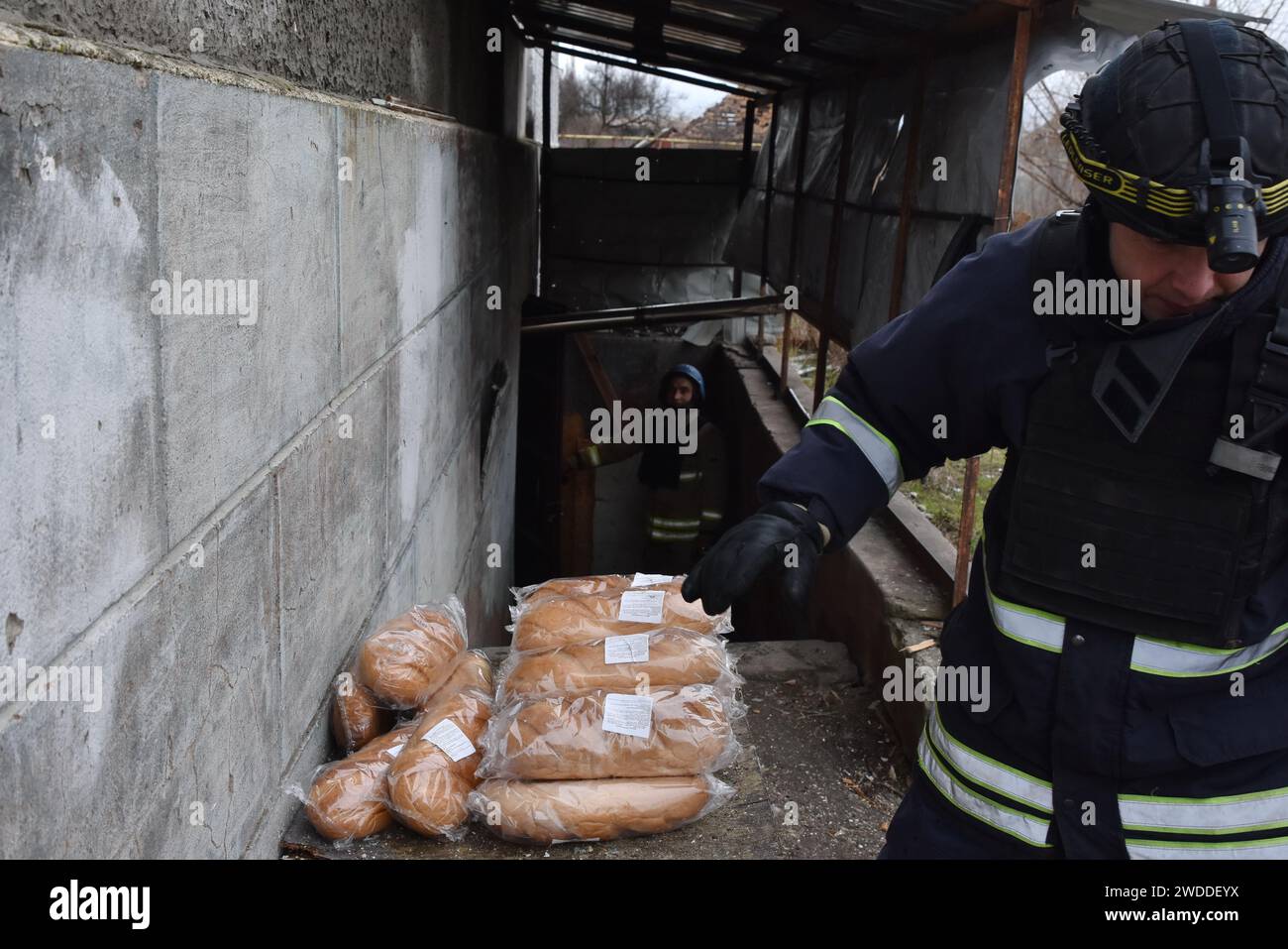 Orikhiv, Ucraina. 18 gennaio 2024. Un soccorritore consegna pane fresco a un rifugio di residenti locali a Orikhiv. Orikhiv è una piccola città vicino a Zaporizhzhia, che funge da ultimo pilastro di resistenza per i soldati dell'esercito ucraino a sud, mentre le forze armate russe continuano ad avanzare verso la Robotyne liberata. I cittadini di Orikhiv, che ospitano circa 700 persone, rischiano la vita sopportando quotidianamente la bomba aerea e gli attacchi di artiglieria mentre lottano per sopravvivere. (Foto di Andriy Andriyenko/SOPA Images/Sipa USA) credito: SIPA USA/Alamy Live News Foto Stock