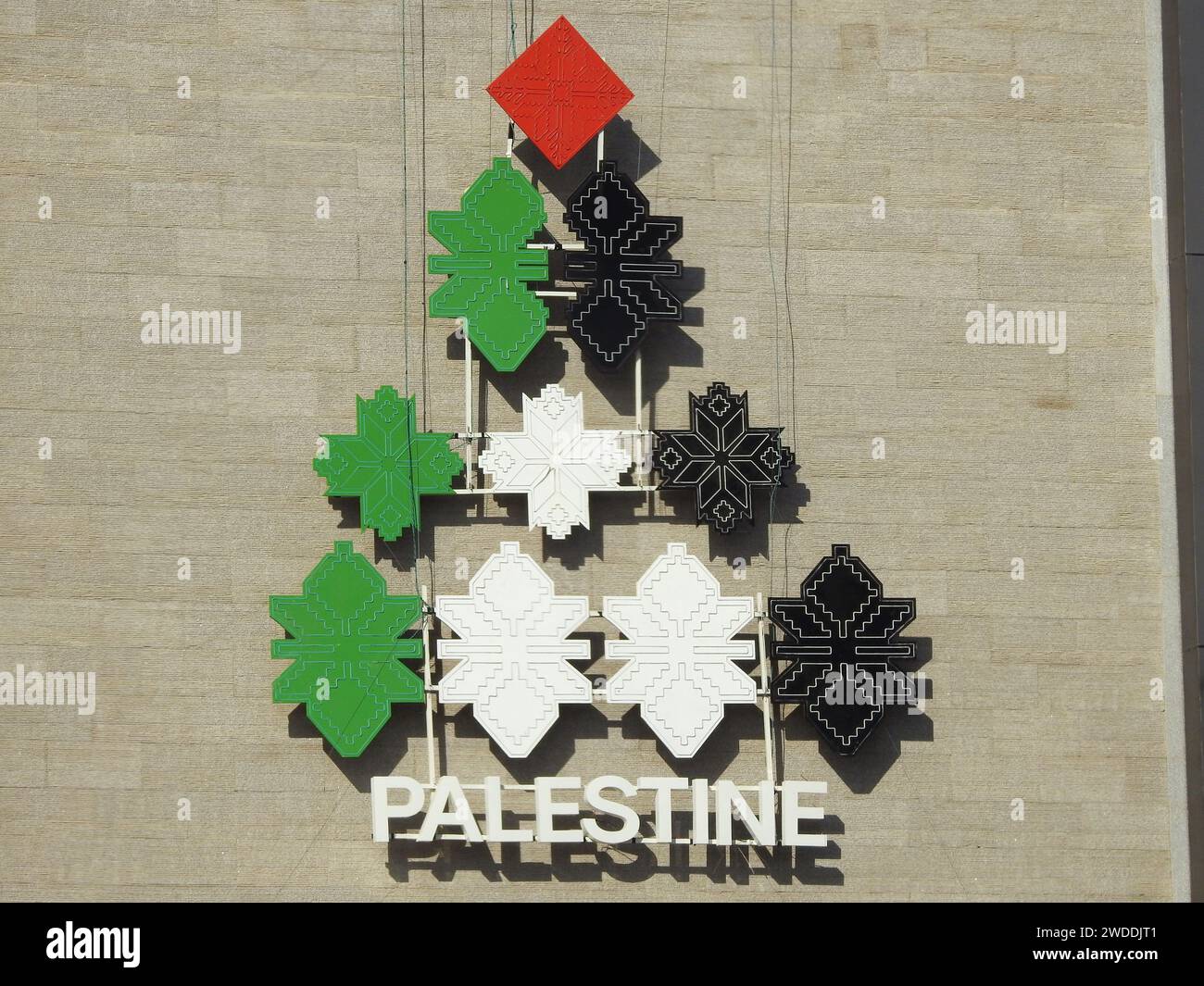 Una forma piramidale con i colori della bandiera palestinese, con la parola Palestina sotto di essa, un'icona su un edificio in Egitto per lo stato della Palestina Foto Stock