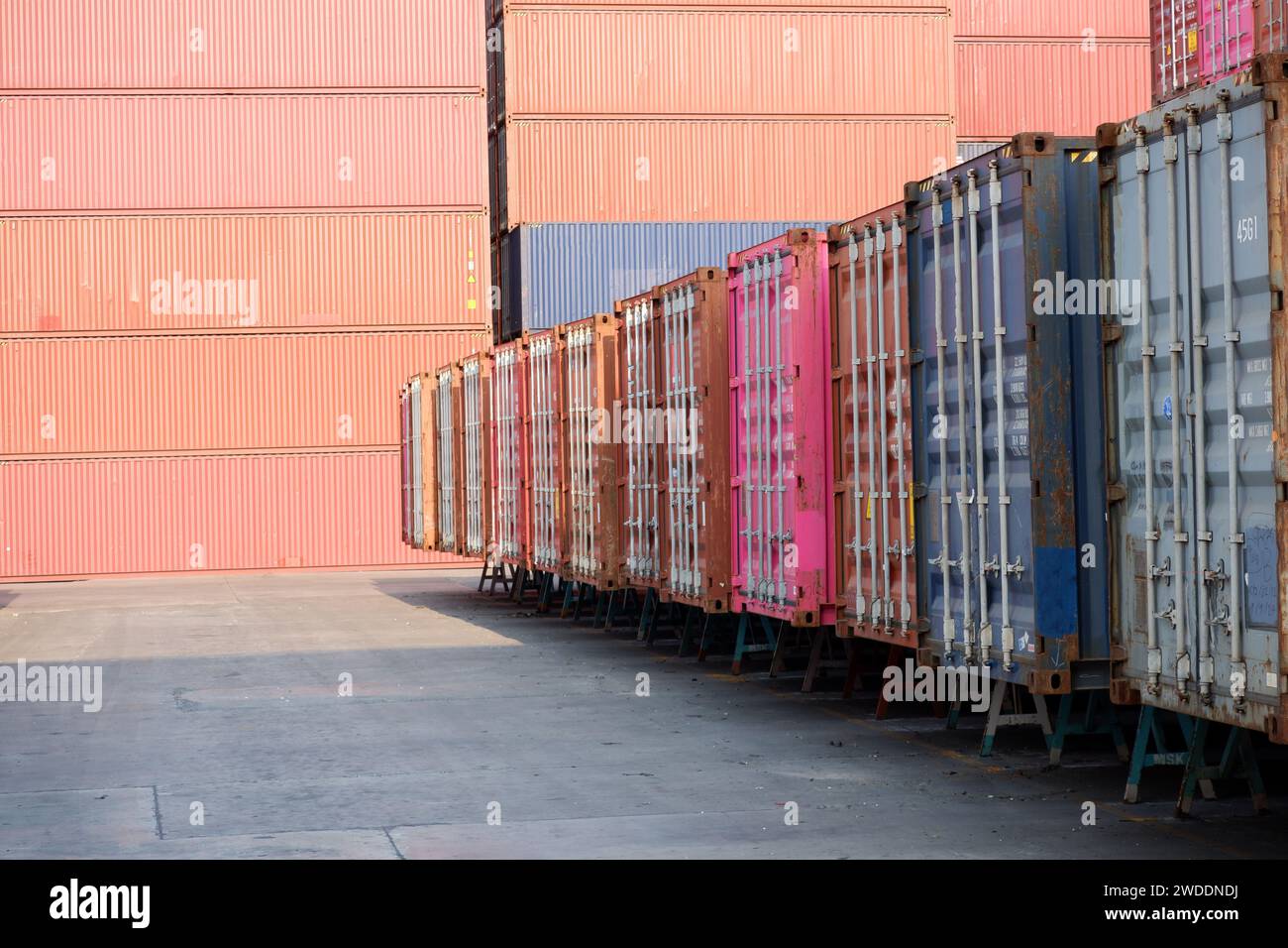 Parete contenitore contenitori multicolore isolati su magazzini bianchi allineati in file contenitori per il trasporto automobilistico o marittimo Foto Stock