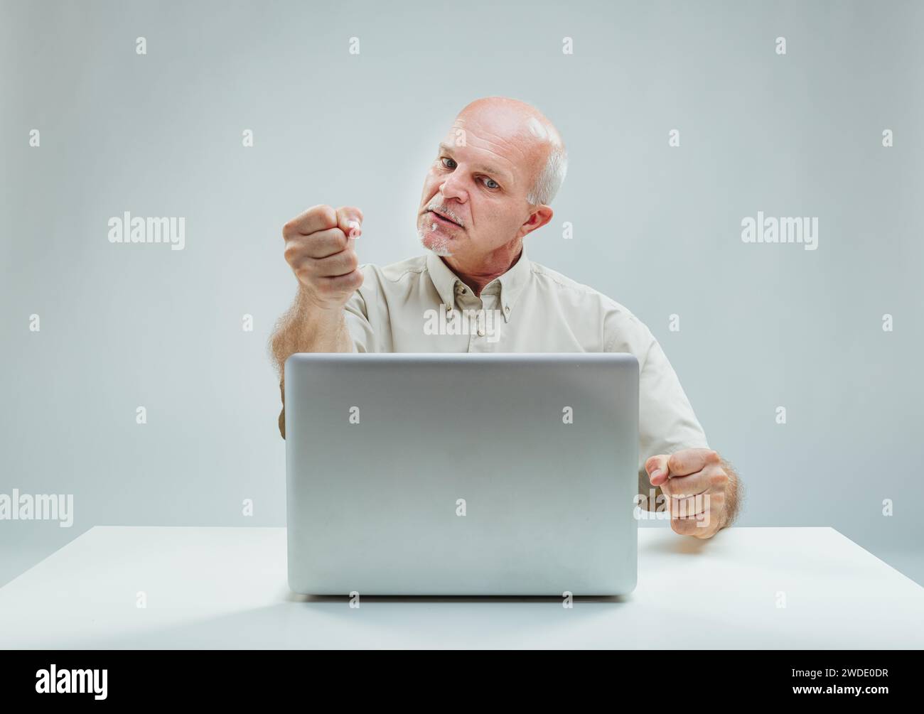 L'uomo si muove con fermezza durante una discussione online, il suo comportamento serio suggerisce un acceso dibattito Foto Stock