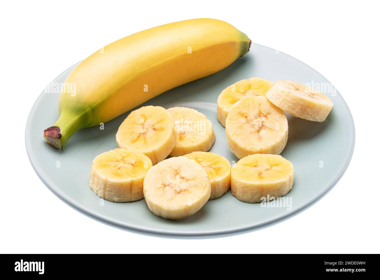 Banane e fette di banana sbucciate su piatto blu. Il file contiene il percorso di ritaglio. Foto Stock