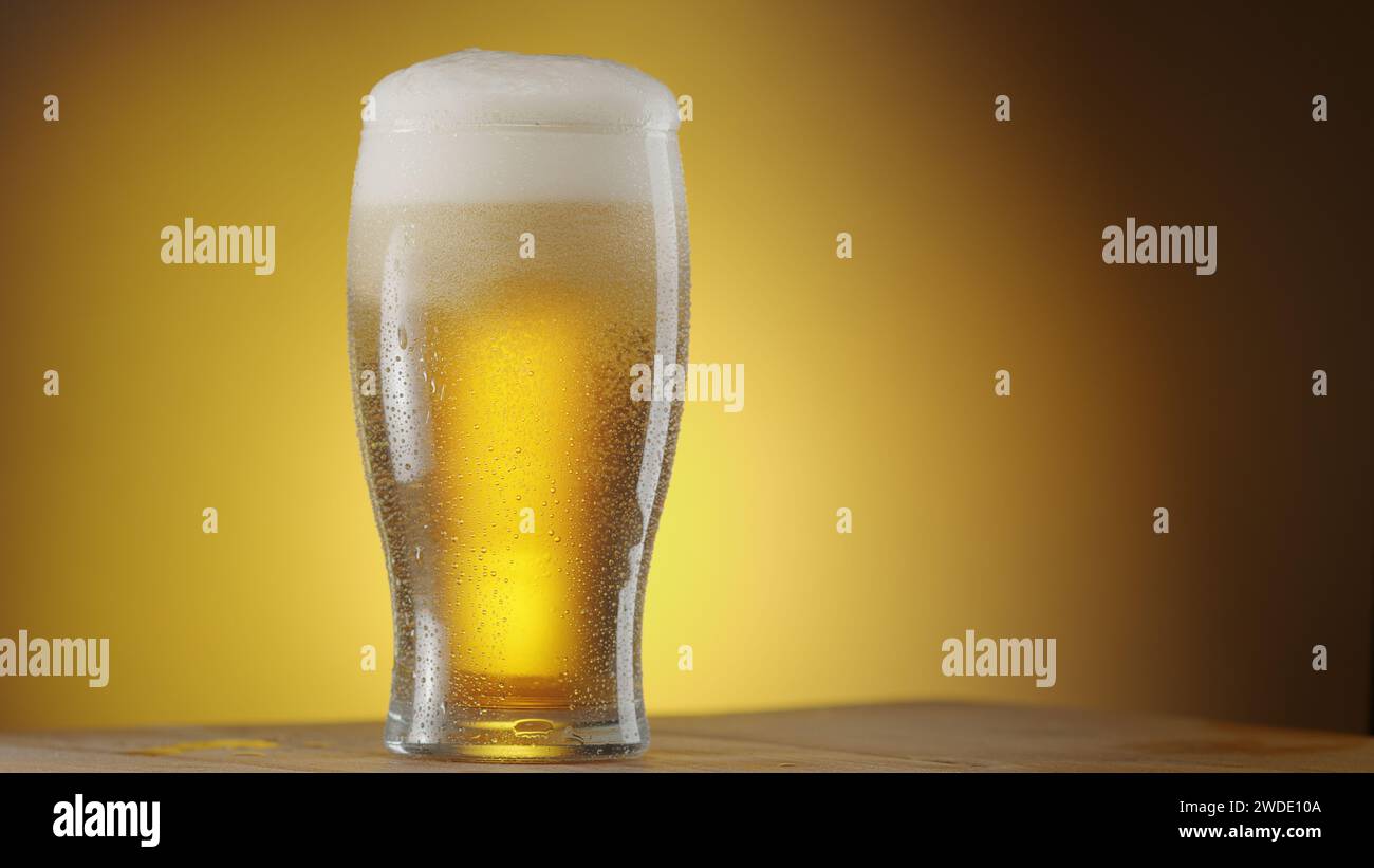 Bicchiere di birra ghiacciata con grande punta di schiuma isolata su sfondo giallo. Foto Stock