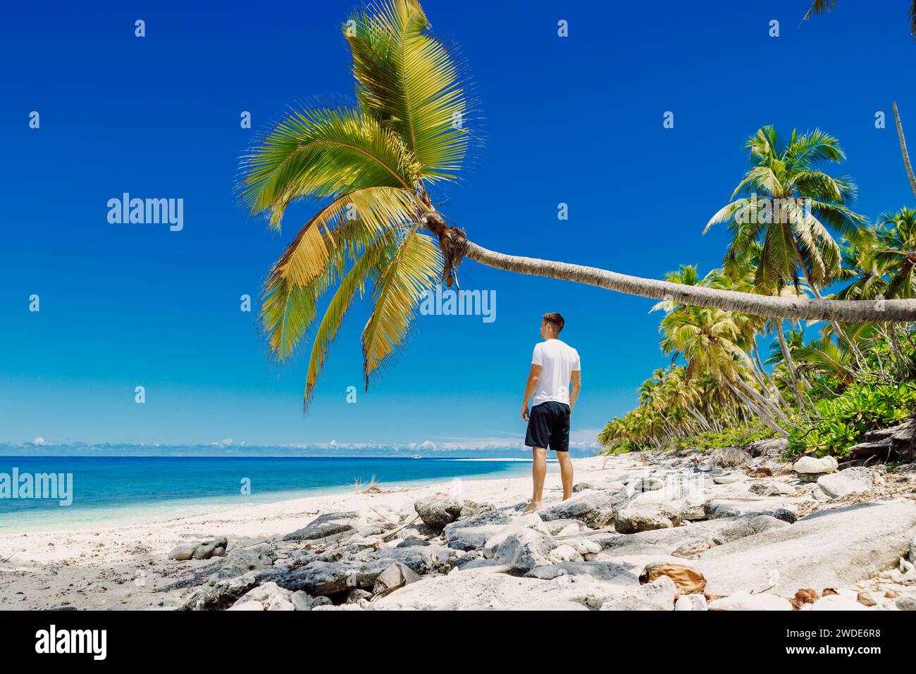 Un uomo che si rilassa sulla spiaggia. Vacanza uomo sottile sulla spiaggia paradisiaca Foto Stock