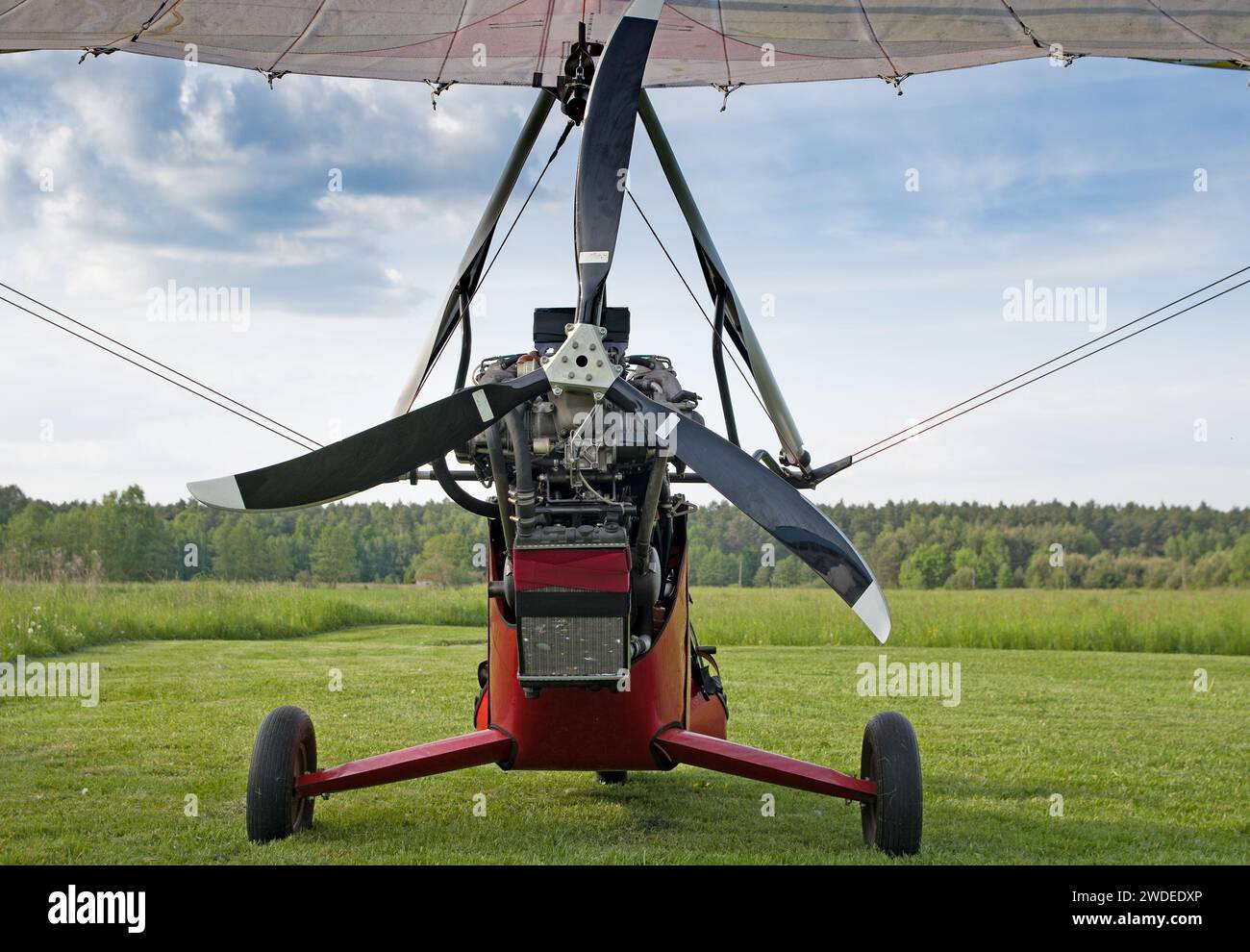Il moderno parapendio motorizzato su una piattaforma di lancio verde in un campo è pronto per il decollo in cielo. Foto Stock