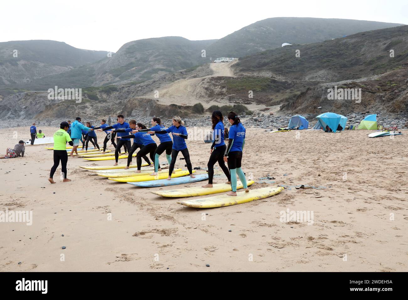 23.07.2019, Sagres, Algarve, PRT - Menschen bei einem Surfkurs am Strand. Ponta Ruiva Beach. 20-30 Jahre, aktiv, Aktivitaet, Algarve, Anfaenger, aussen, Aussenaufnahme, Europa, europaeisch, Freizeit, Freizeitaktivitaet, Freizeitbeschaeftigung, Funsport, Gesellschaft, Gruppe, Jahreszeit, Kaukasier, kaukasisch, lehren, Lehrer, lernen, Menschen, Personen, Portogallo, portugiesisch, QF, Querformat, Sagres, Sommer, sportlich, trefolo, tavole da surf, Surfretter, Surfen, Surfer, surf, Surfkurs, Surflehrer, Trockenuebung, Trockenuebungen, ueben, Uebung, Wassersport, Westeuropa 190723D094PORTUGAL.JPG *** Foto Stock