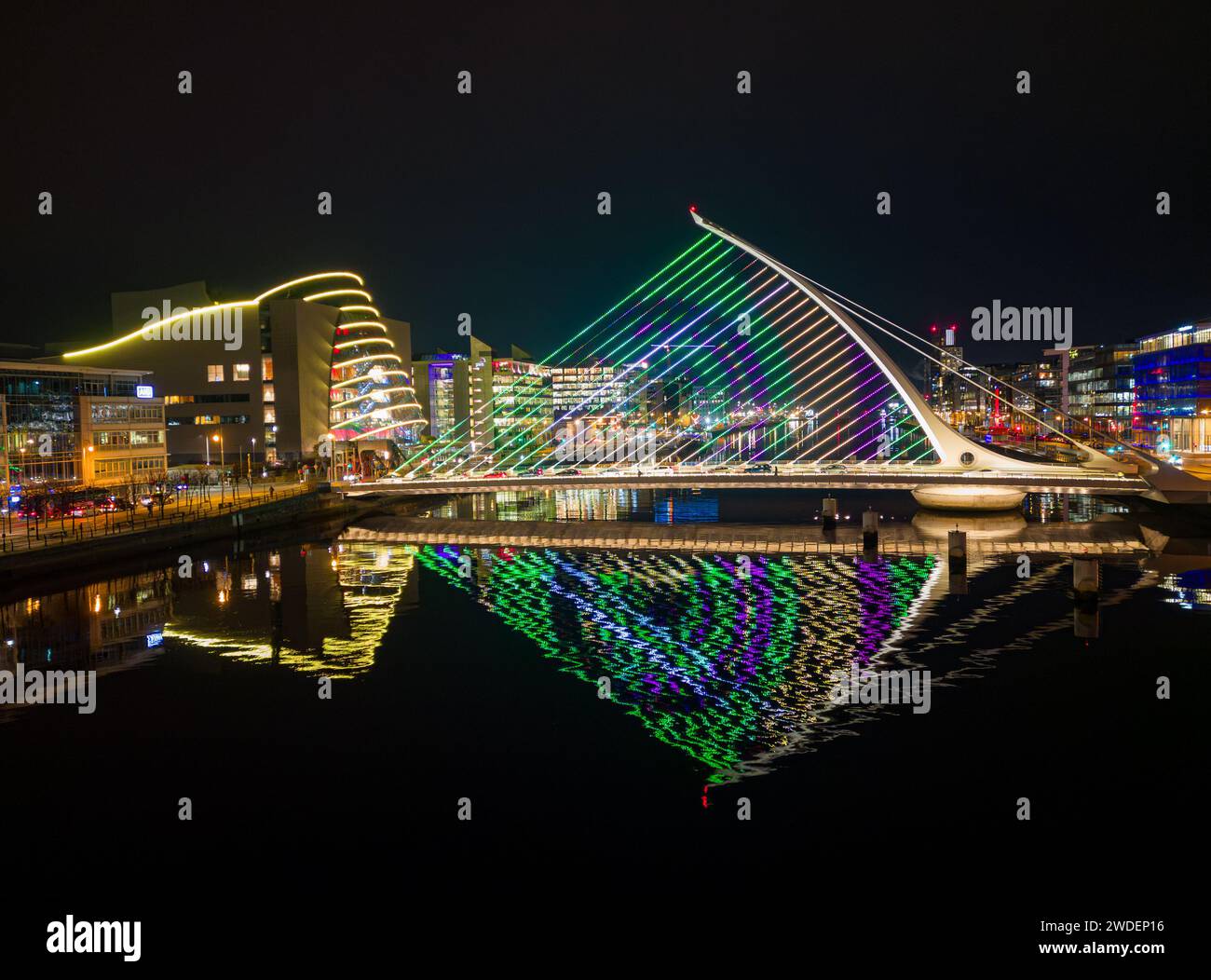 Luci invernali 2023 illuminano il Samuel Beckett Bridge e riflettono nel Liffey in una notte tranquilla Foto Stock