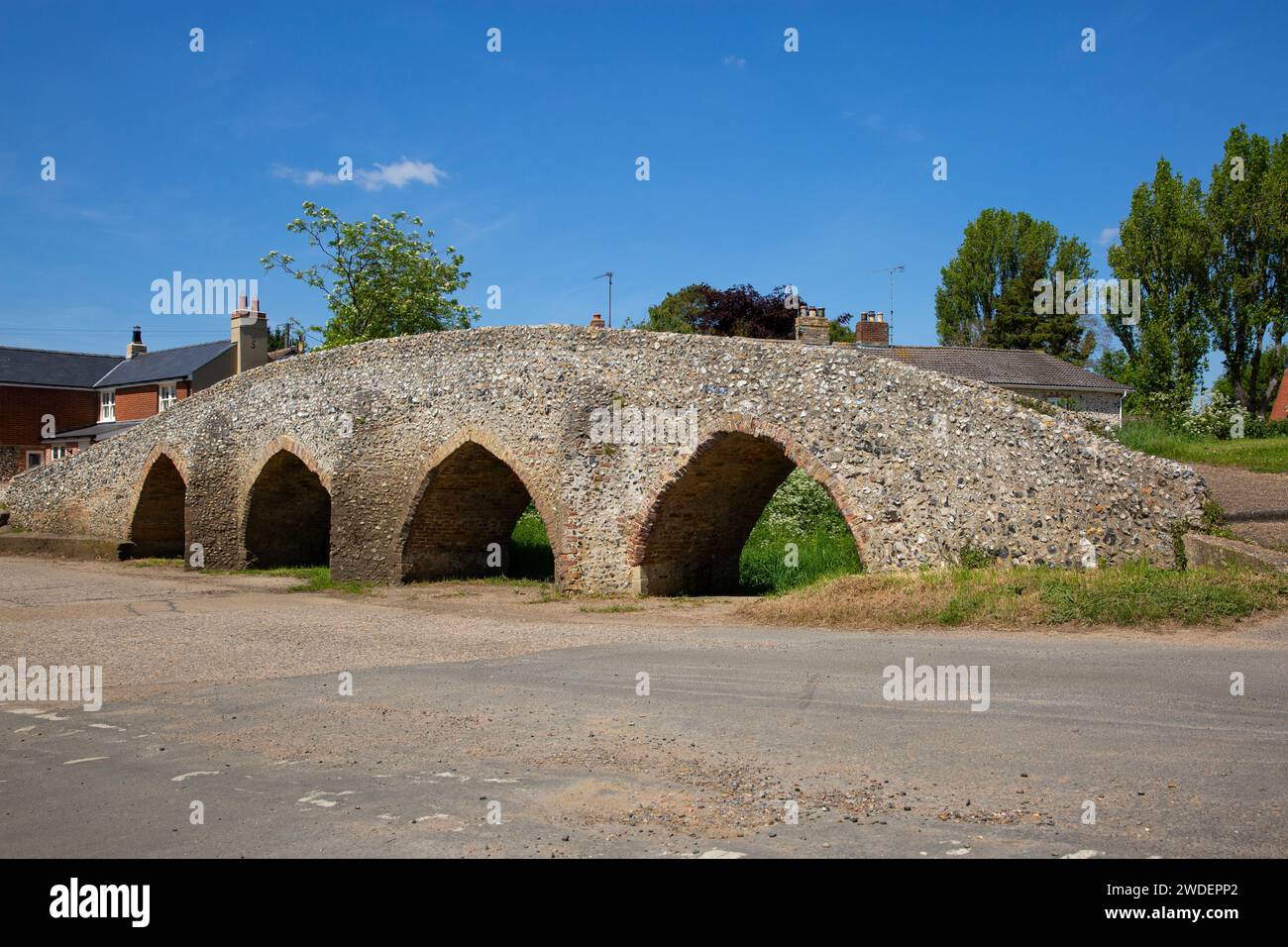 Lo storico Packhorse Bridge del XV secolo con i suoi quattro archi sul fiume Kennett nel villaggio di Moulton, Suffolk Foto Stock