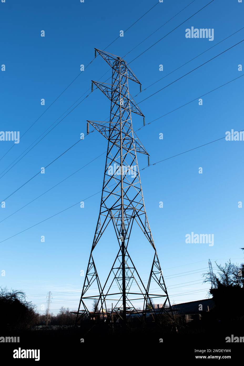 Guarda verso l'alto il pilone elettrico della rete nazionale da un angolo basso, da sotto, Inghilterra, Regno Unito, con cielo azzurro Foto Stock