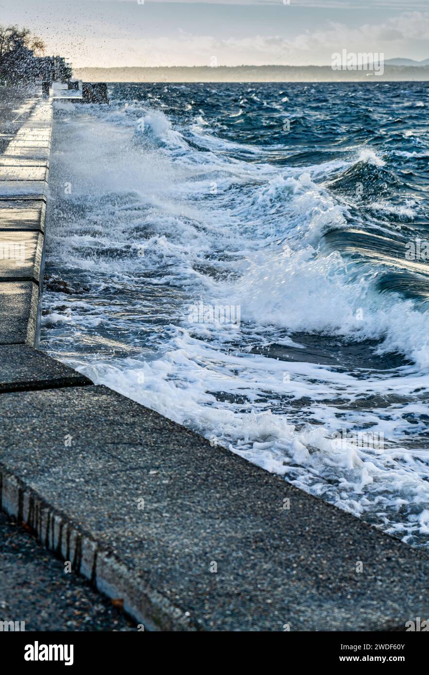 Le onde si infrangono sulla parete del mare di Alki Beach a West Seattle, Washington. Foto Stock