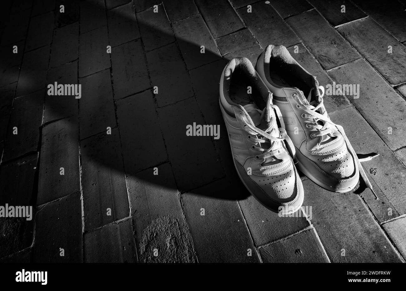 Vecchie scarpe sportive sul pavimento Foto Stock