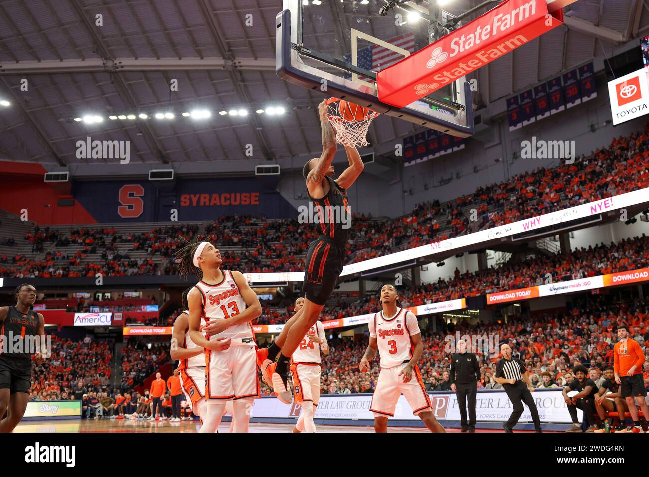 Syracuse, New York, USA. 20 gennaio 2024. Durante la partita di basket della conferenza ACC tra la Syracuse University e la Miami University, la guardia di Miami MATTHEW CLEVELAND (0) sbatte la palla in casa, mentre l'attaccante di Syracuse BENNY WILLIAMS (13) guarda durante la seconda metà della partita tenutasi al JMA Wireless Dome nel campus della Syracuse University. (Immagine di credito: © Scott Rausenberger/ZUMA Press Wire) SOLO USO EDITORIALE! Non per USO commerciale! Foto Stock