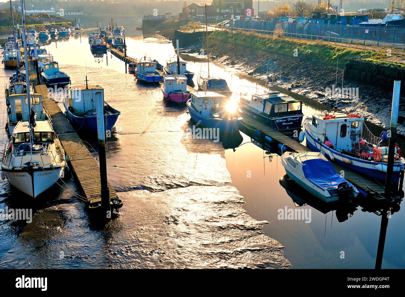 Il fangoso Wallsend Burn e le sue barche fluiscono nel fiume Tyne al sole del mattino presto Foto Stock