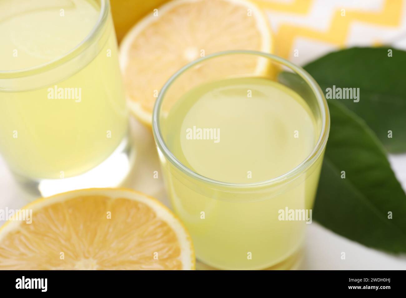 Gustoso liquore al limoncello e limoni sul tavolo, primo piano Foto Stock
