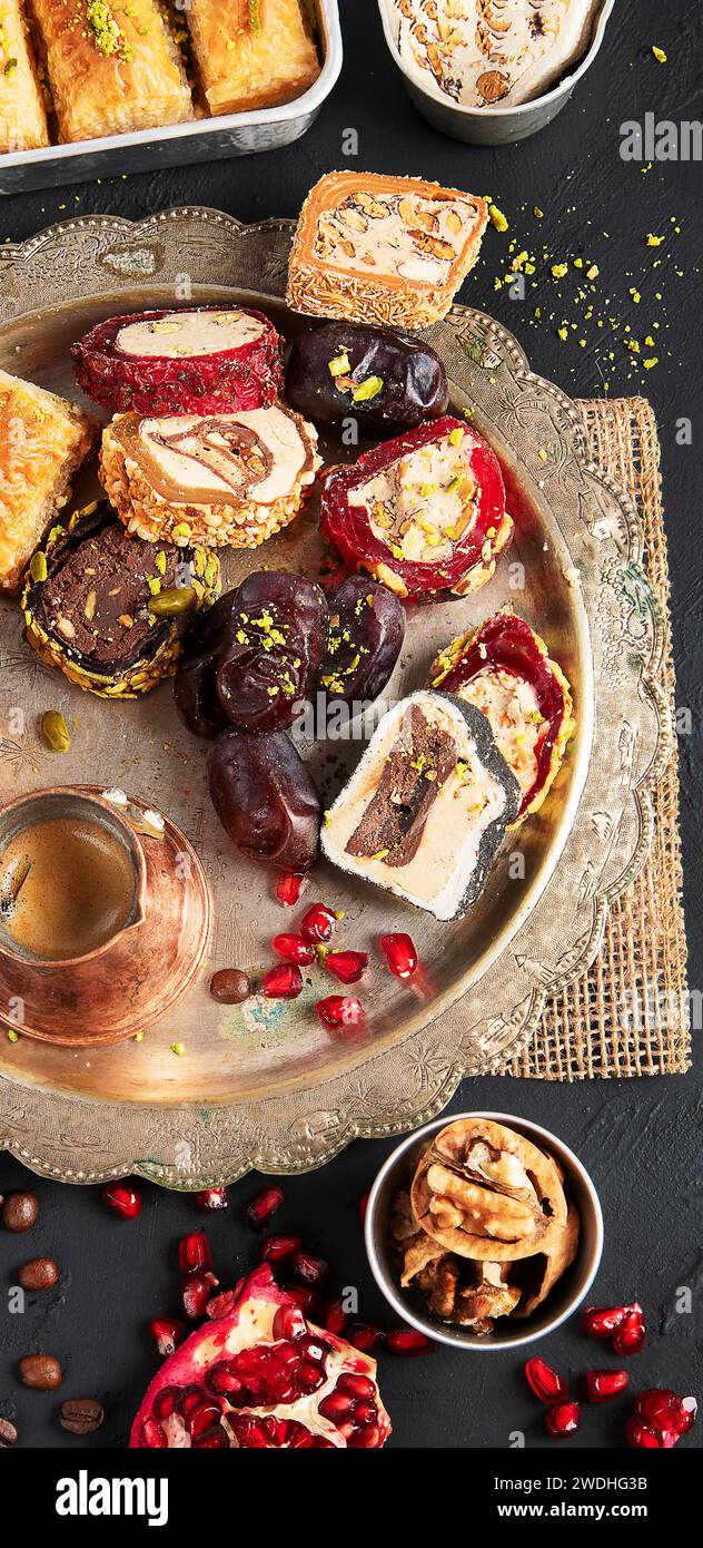 Caffè caldo e gustoso con vari pezzi di delizia turca su uno sfondo scuro. Cucina tradizionale araba. Foto Stock