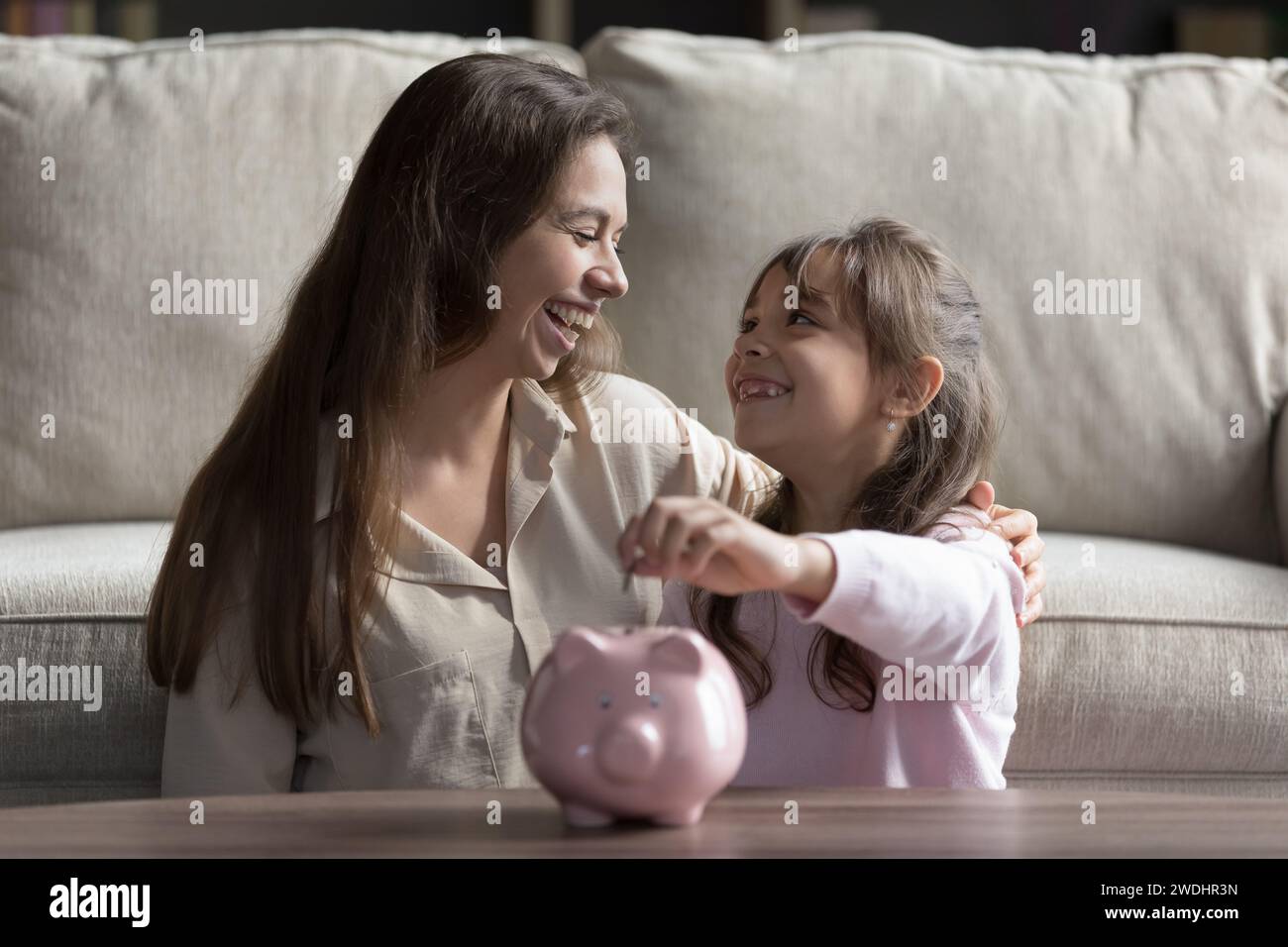 Bambino piccolo ha messo monete nel salvadanaio Foto Stock