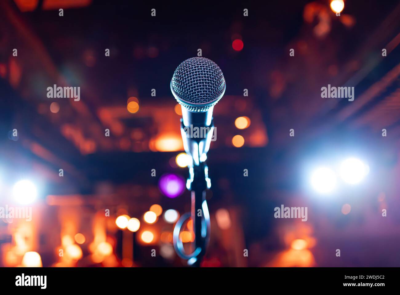Spettacolo pubblico sul palco microfono sul palco sullo sfondo di un auditorium. Profondità di campo ridotta. Foto Stock