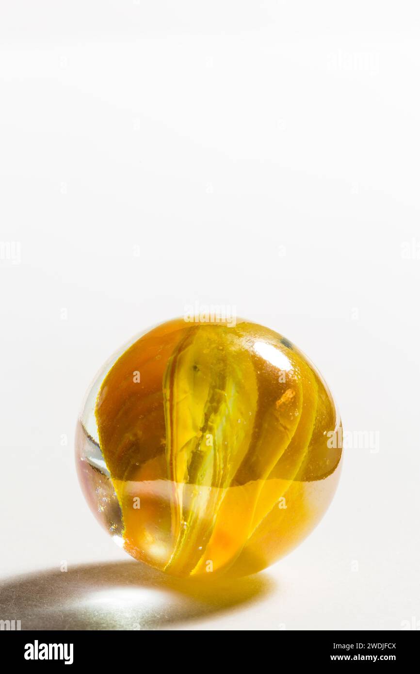 Un marmo di vetro a nastro giallo. Foto Stock