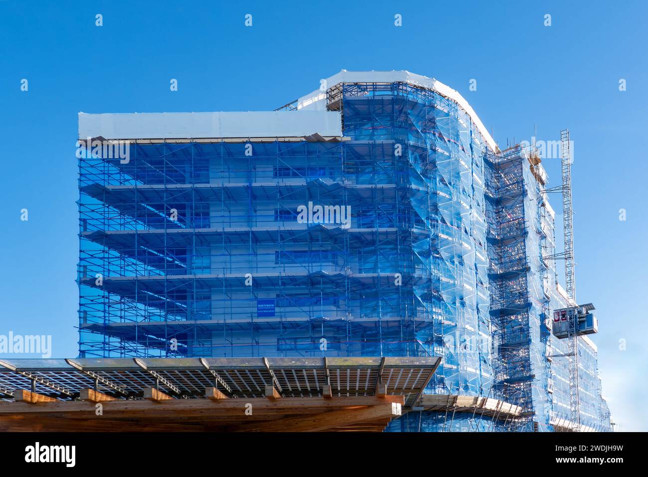 Portishead, Regno Unito: Un'ampia impalcatura coperta da rete blu posizionata intorno al blocco di appartamenti Mirage per facilitare la sostituzione del rivestimento esistente Foto Stock