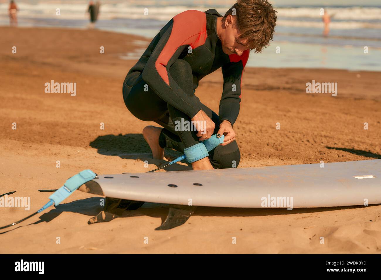 Surfista in muta con tavole da surf si prepara a cavalcare sulle onde Foto Stock