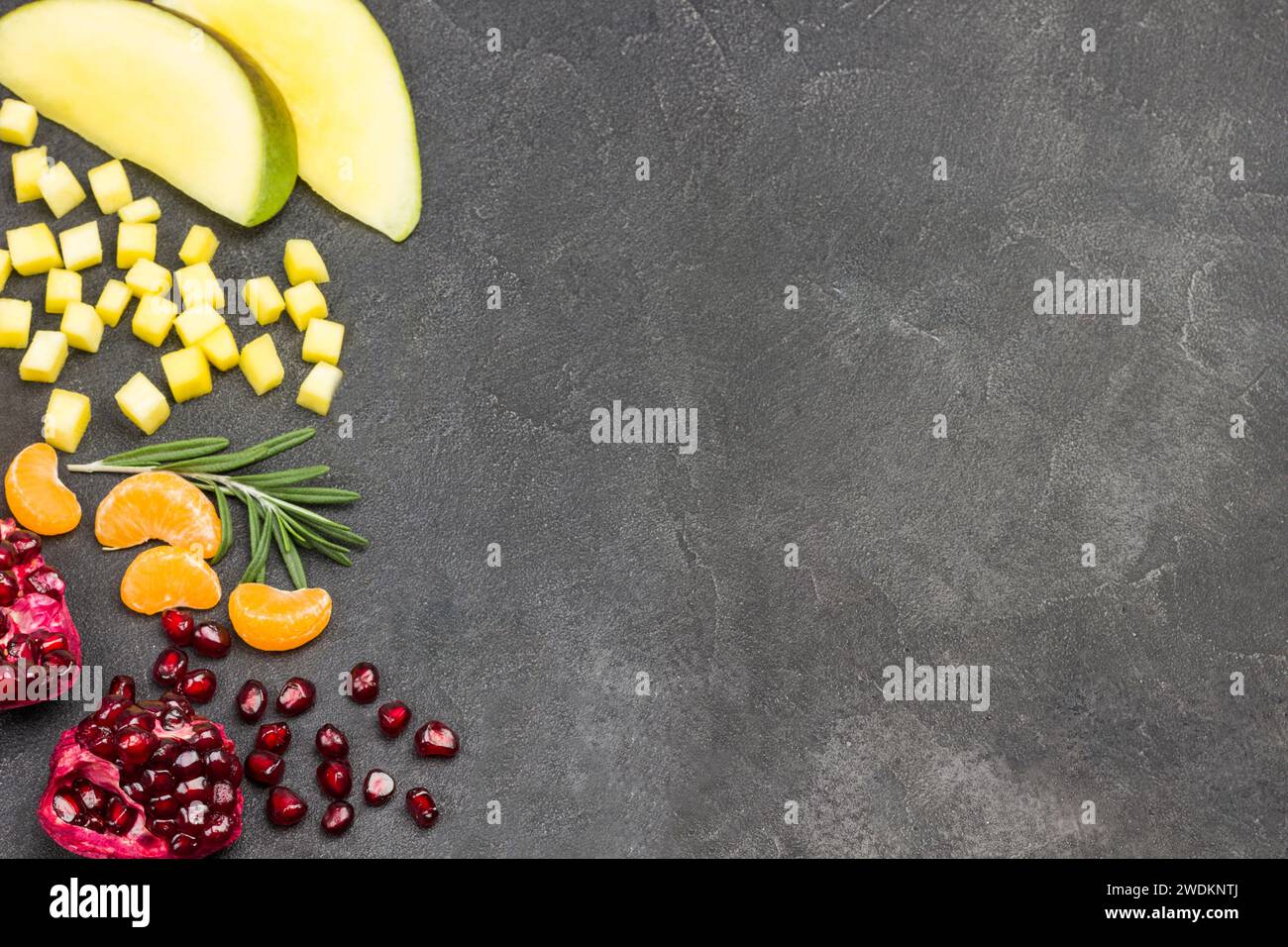 Natura morta del mango, melograno su sfondo nero. Copia spazio. Spianatura piatta. Dieta sana cibo vegetariano. Foto Stock