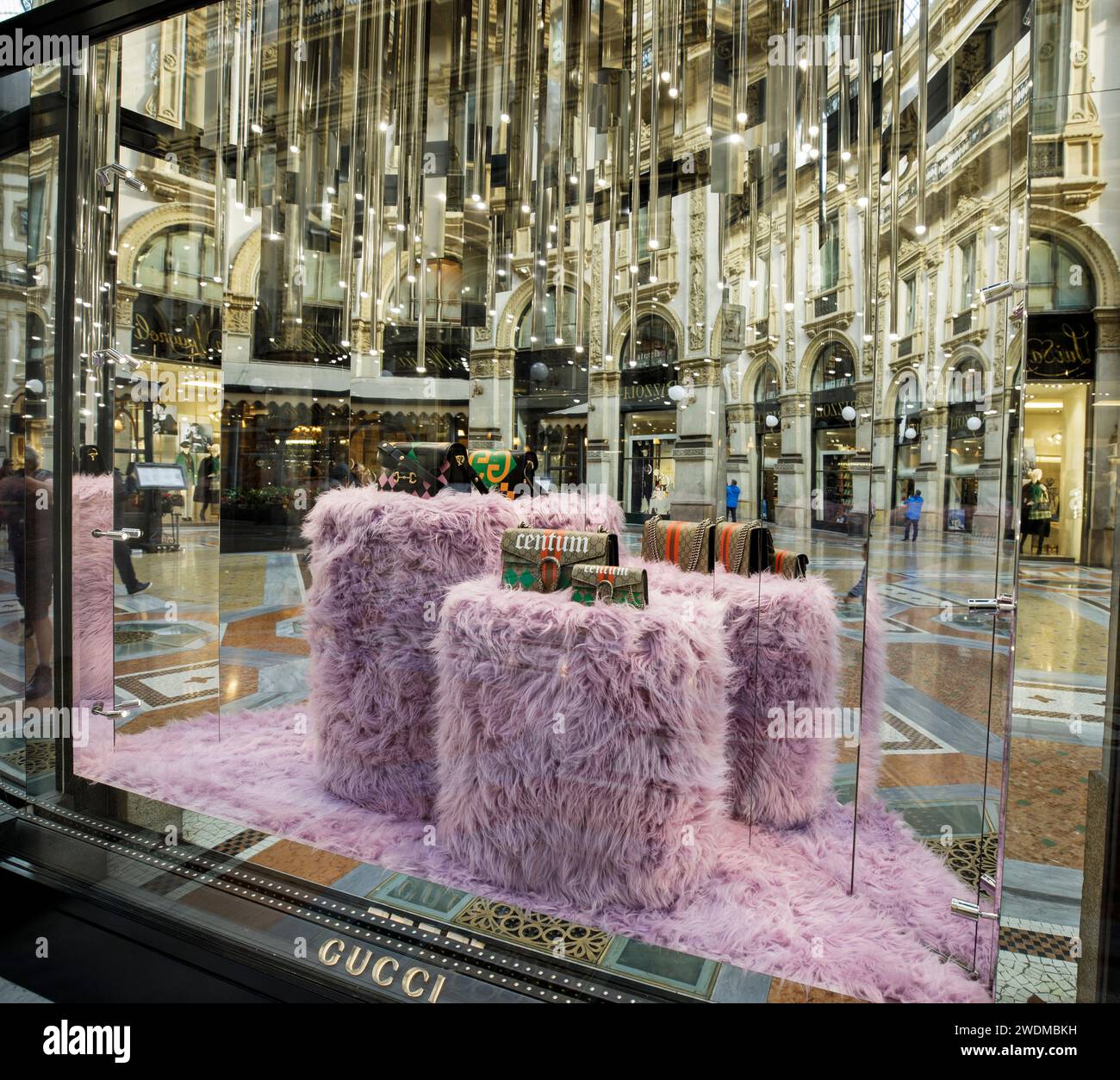 Vetrina per il negozio Gucci nella galleria di negozi di lusso di Milano Vittorio Emanuele II, con cubi, specchi e borse viola morbidi. Foto Stock