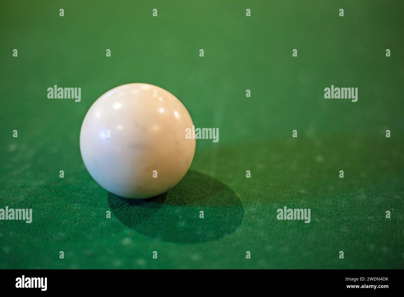 Primo piano in formato orizzontale di una palla bianca da snooker su un tavolo coperto in baize verde. Foto Stock