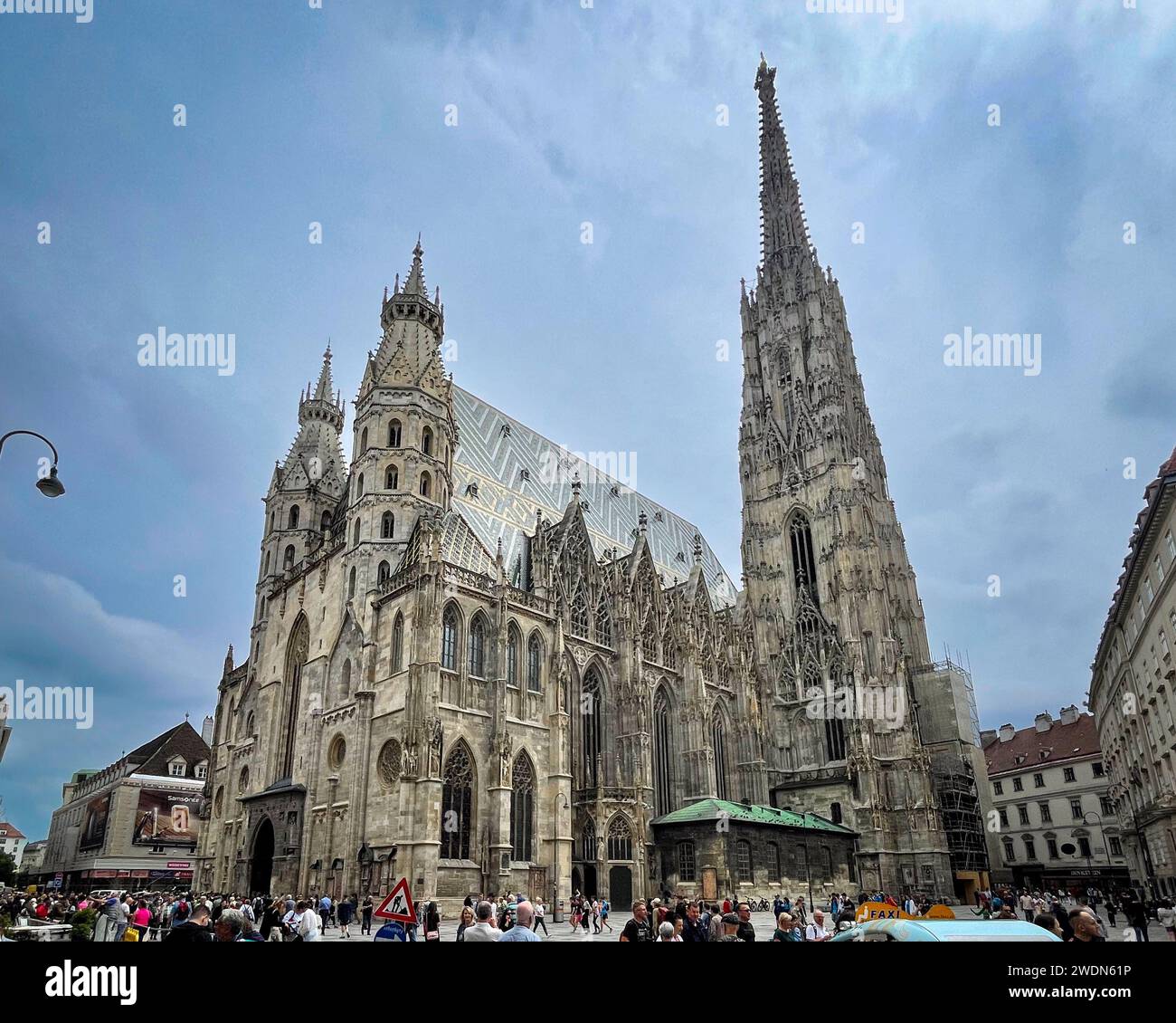 Vienna, AT - 9 giugno 2023 tre quarti Vista verticale dei turisti che visitano l'esterno anteriore della chiesa romanica e gotica di St Stephen's Cathedral Foto Stock