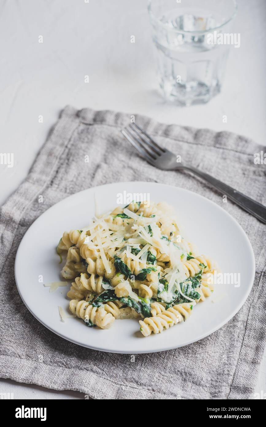 Pasta cremosa di spinaci con ricotta e parmigiano su piatto bianco Foto Stock