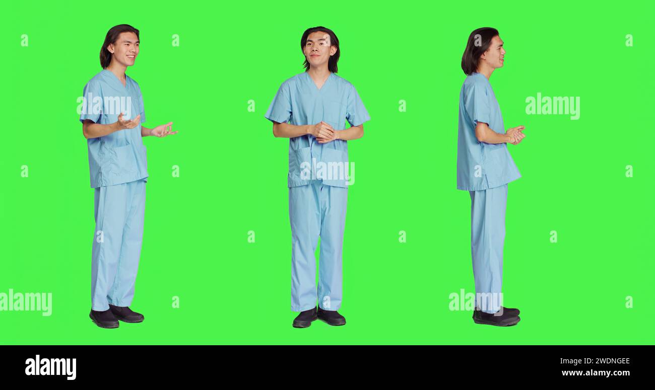 Allegra infermiera che salutava in studio e salutava le persone malate, in piedi su uno sfondo a schermo verde. Assistente medico specialista essere rispettoso e amichevole con i pazienti, uniforme sanitaria. Foto Stock