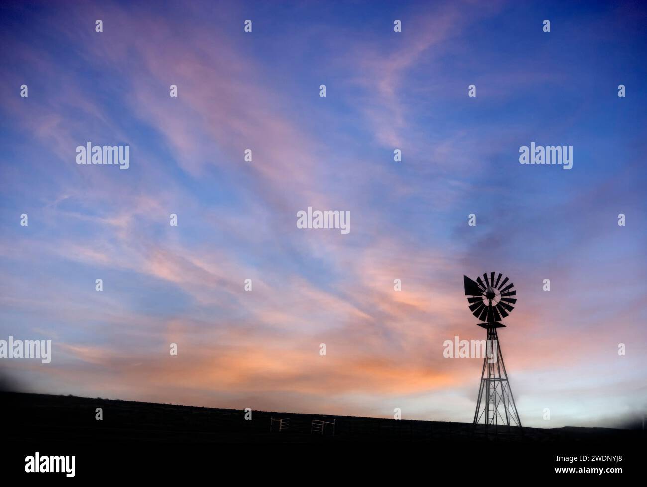 Il mulino a vento Lonley Texas Prarie è caratterizzato da splendide nuvole al tramonto Foto Stock
