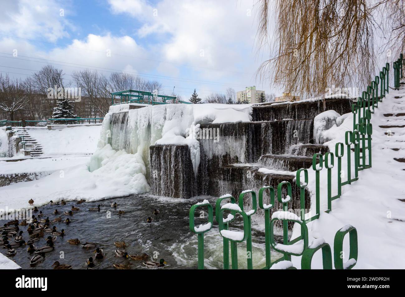 Paesaggio invernale con ruscello e cascata in un parco cittadino in Europa Foto Stock