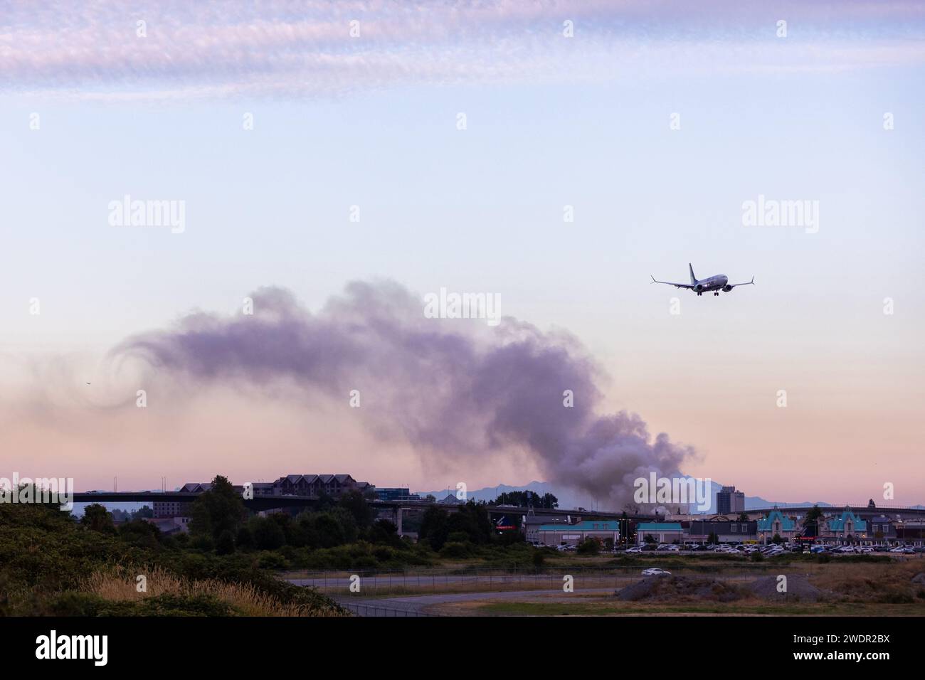 VANCOUVER, British Columbia, CANADA - 27 LUGLIO 2023: Boeing 737 Max con fuoco nei pressi di YVR a Richmond, British Columbia, con Mount Baker sullo sfondo, fumo nero Foto Stock