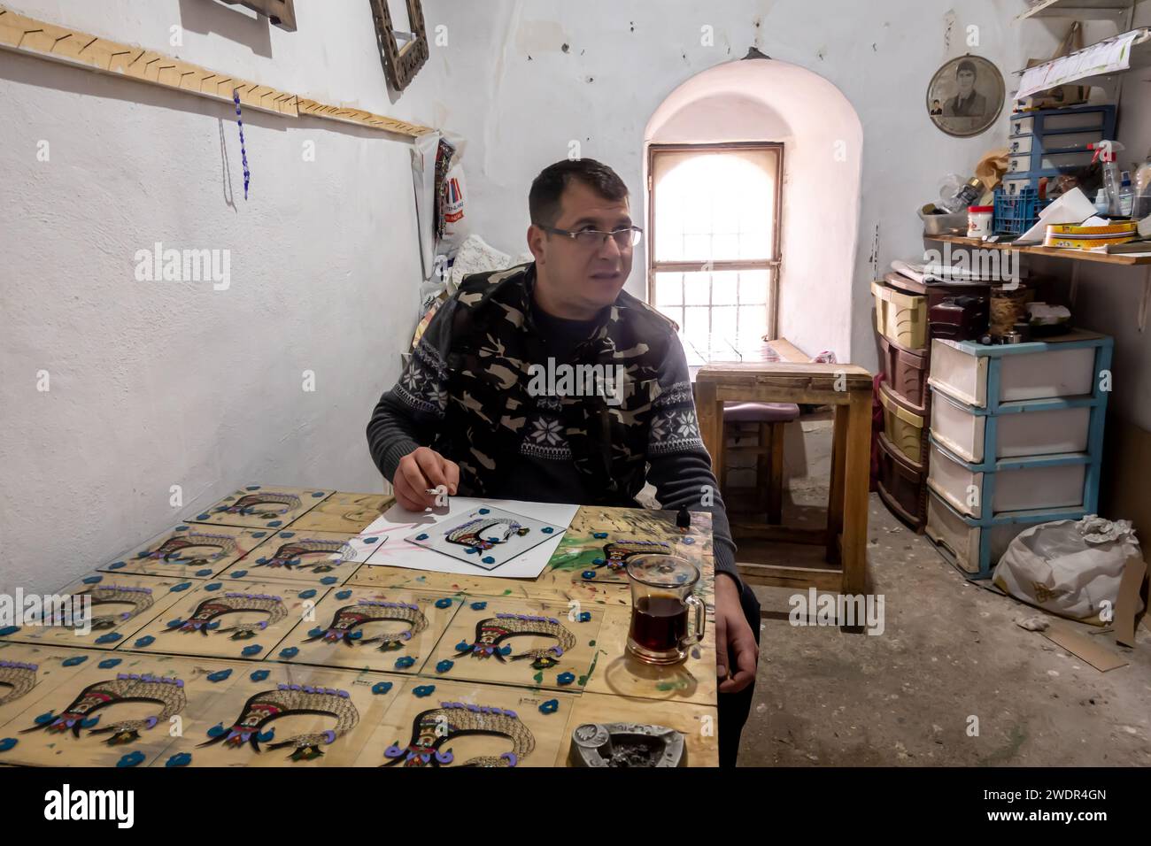 Laboratorio di pittura del vetro Mardin. Mardin artigiano che fa vetri dipinti con l'immagine Shahmaran - il simbolo di Mardin Foto Stock
