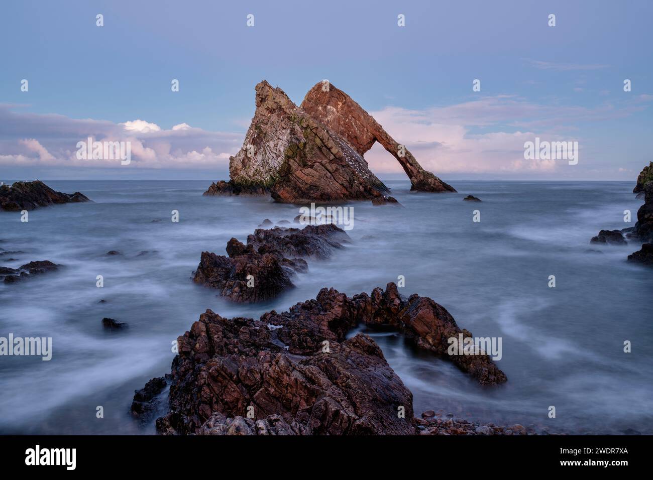 Bow Fiddle Rock al crepuscolo di dicembre. Portknockie, Morayshire, Scozia. Esposizione lunga Foto Stock