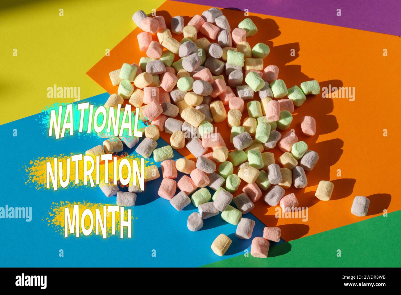 National Nutrition Month con un divertente contrasto di marshmallow zuccherati su un sfondo multicolore, che scatena il dialogo sulle scelte alimentari sane. Foto Stock