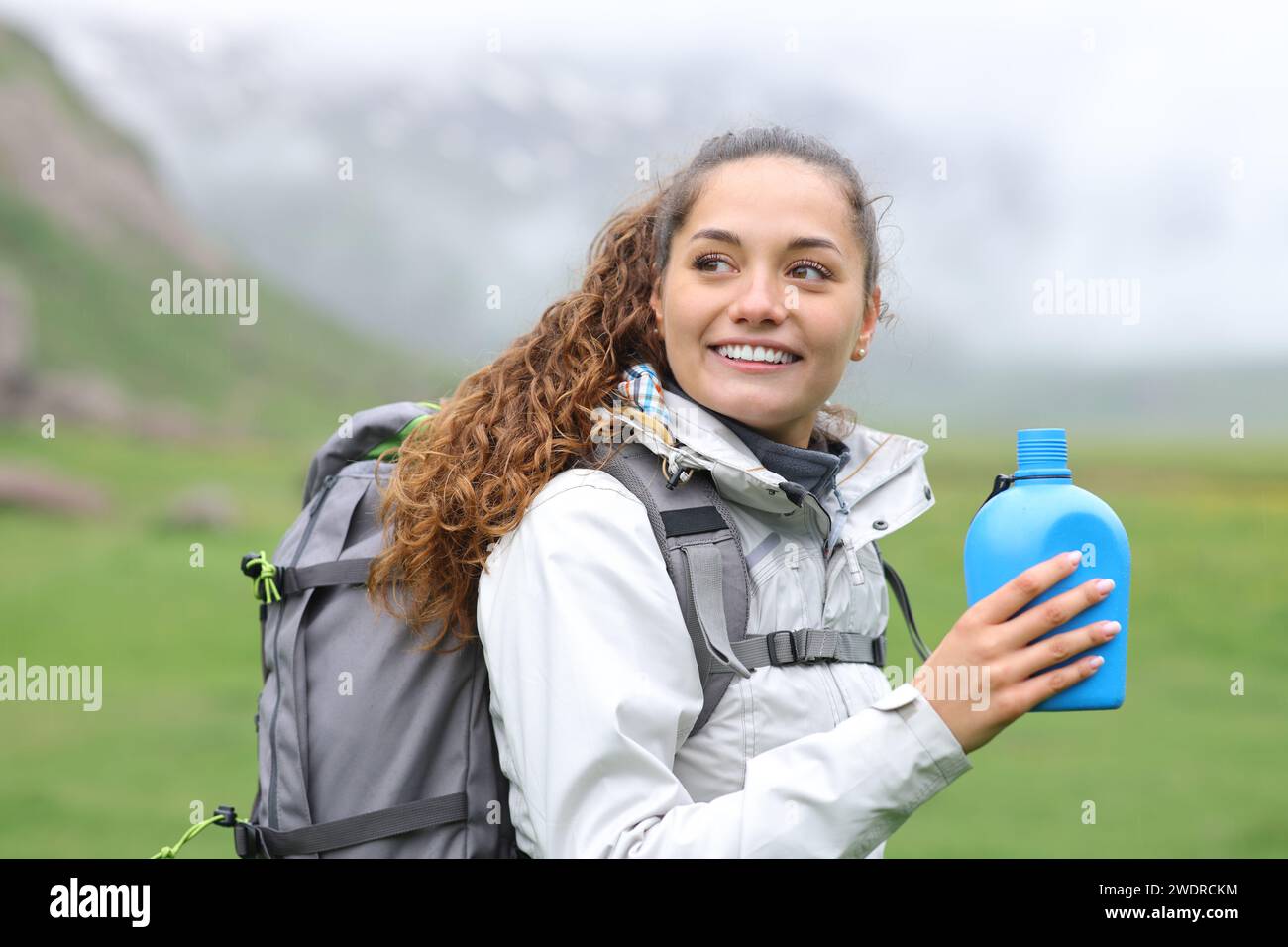 Buon escursionista che tiene una mensa d'acqua che cammina nella natura Foto Stock